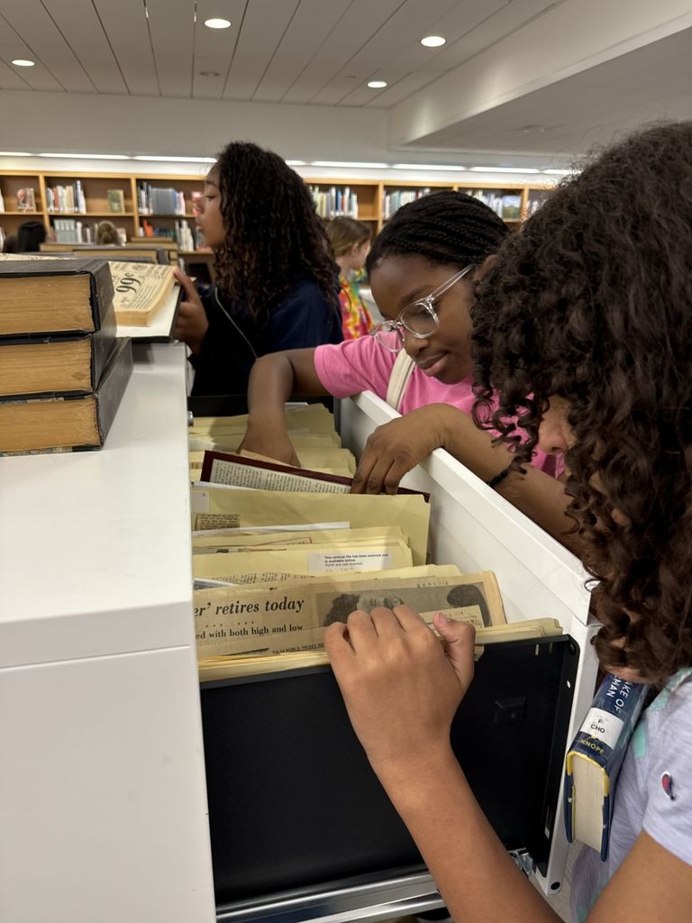 Group of JWI students at the Tulsa Central Library for a field trip, looking through archives.