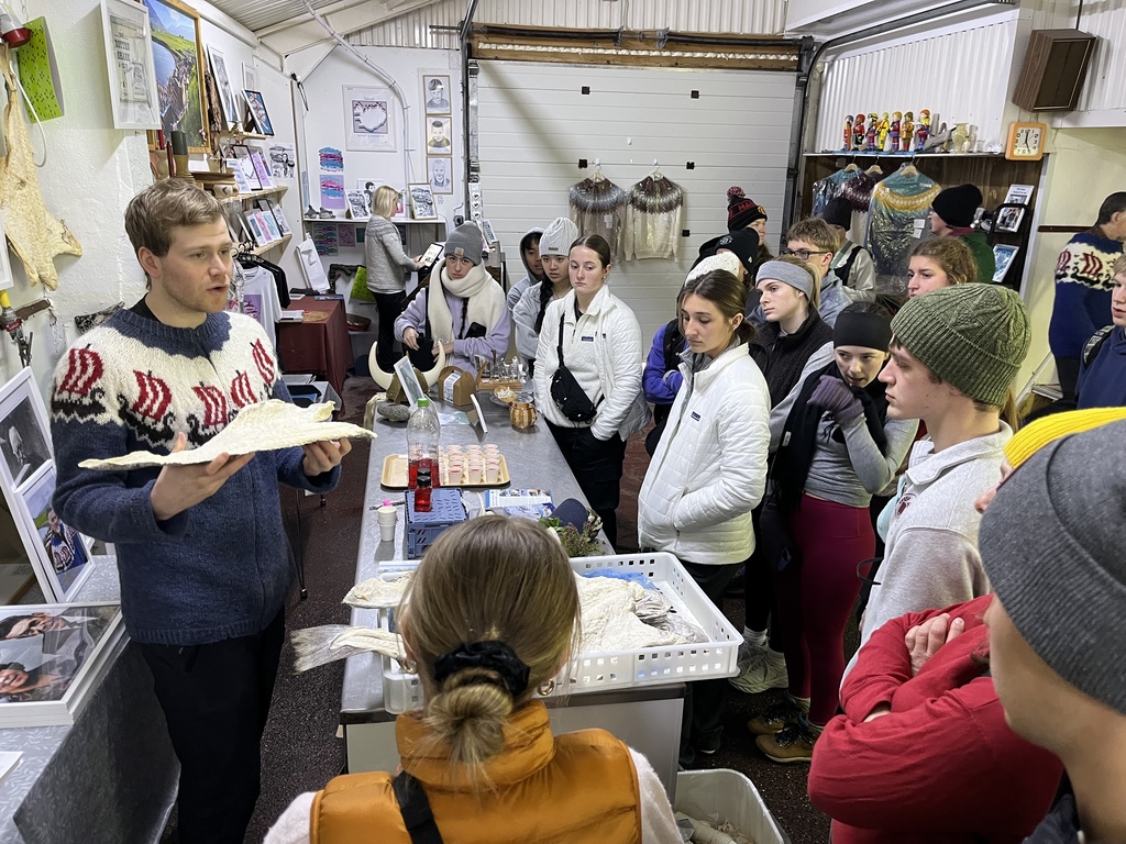 A man showing students a fish skin to students.