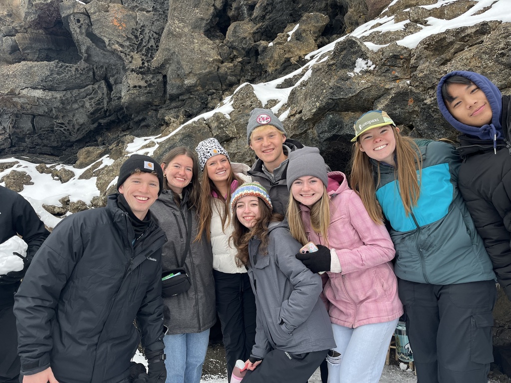 Students posing for a photo bundled up in coats, gloves, and beanies.