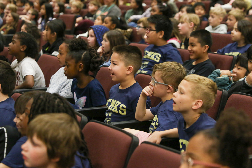 second grade students in their seats smiling and laughing