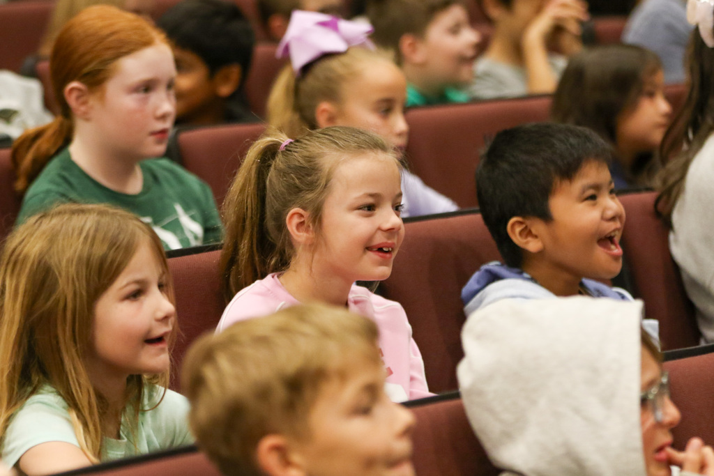 second grade students in their seats smiling and laughing