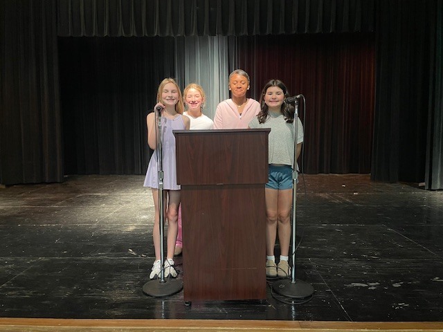 6th grade student announcers behind podium
