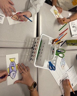 students coloring paper fish