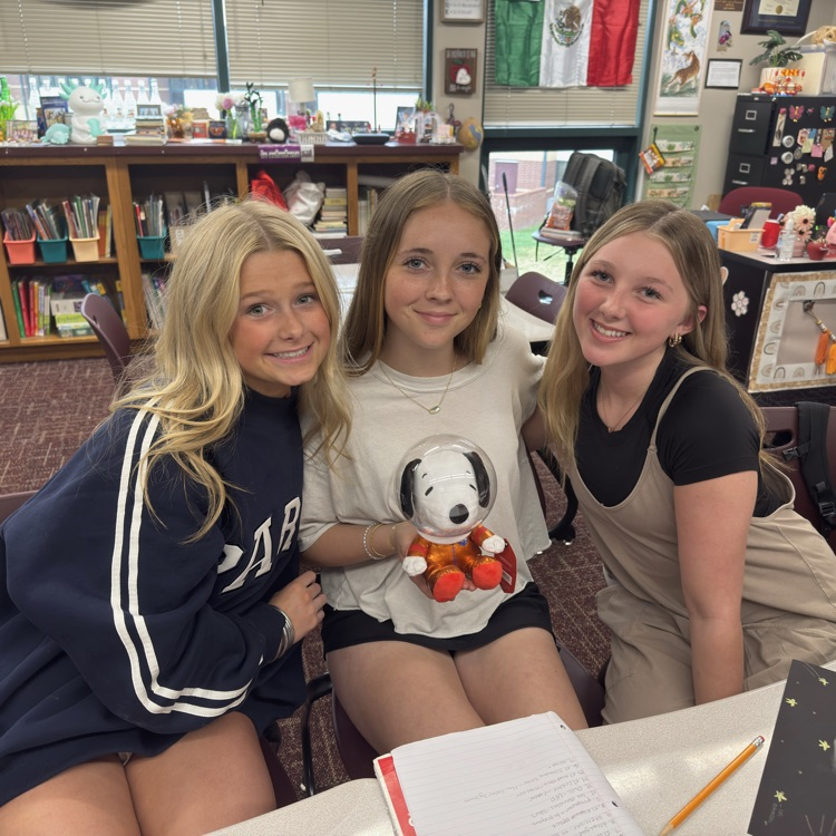 3 students with a Snoopy astronaut 