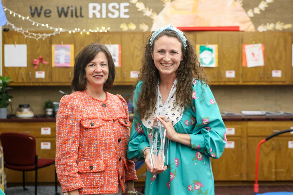 Macy and Dr. Butterfield smiling for a photo with Macy holding her award.
