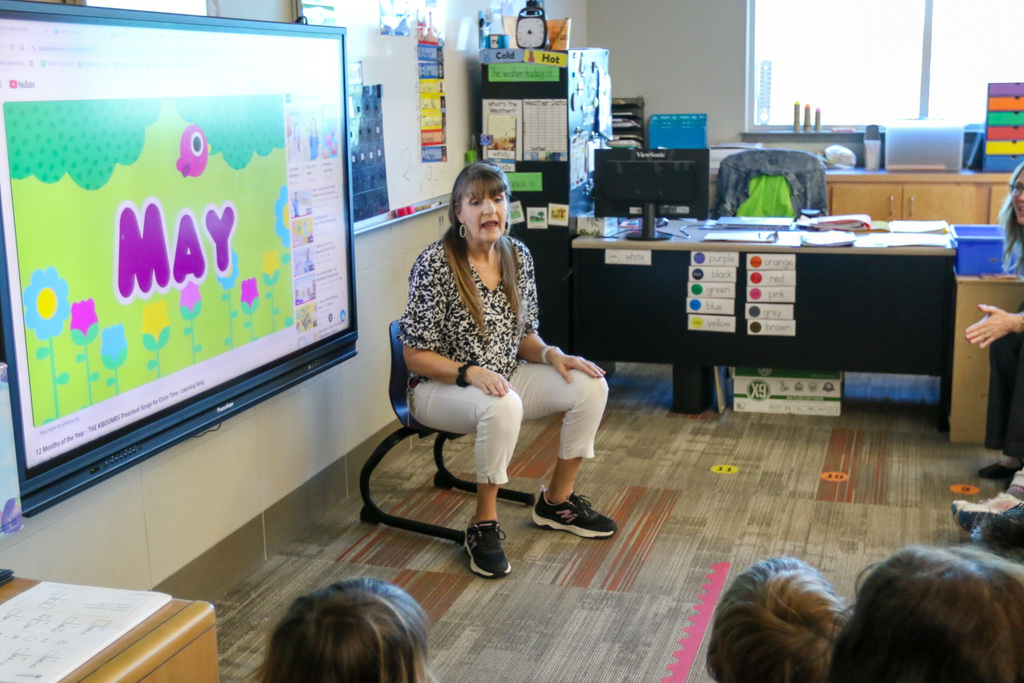 Teacher singing the months of the year. on the screen says May