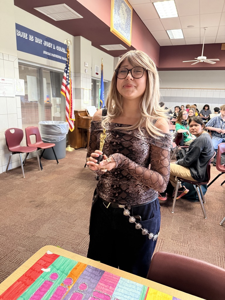 a student holding a replica of an Oscar award