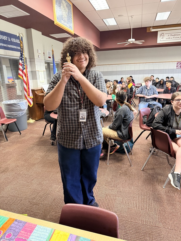 a student holding a replica of an Oscar award