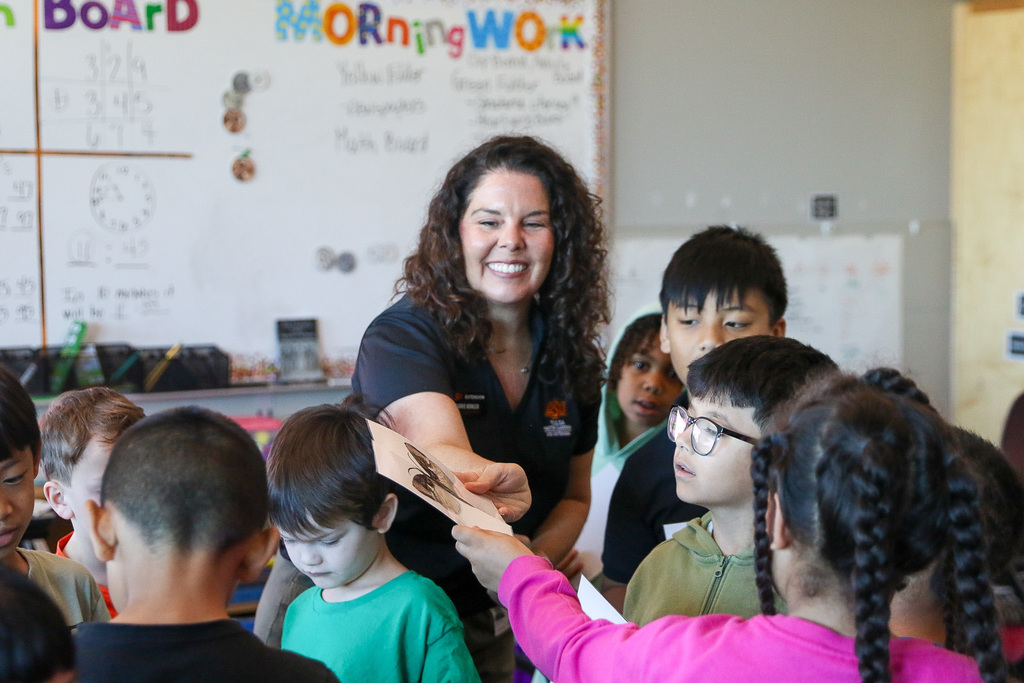 Oklahoma State Master Gardener holding her half of a moth to a students other half