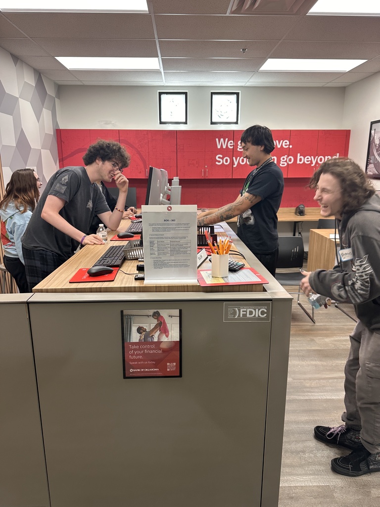 three students around a computer station