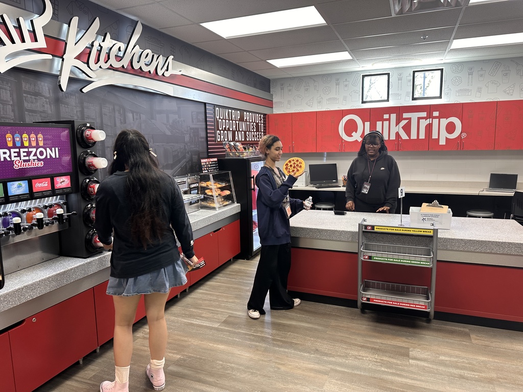 3 students "working" at a replica QuikTrip