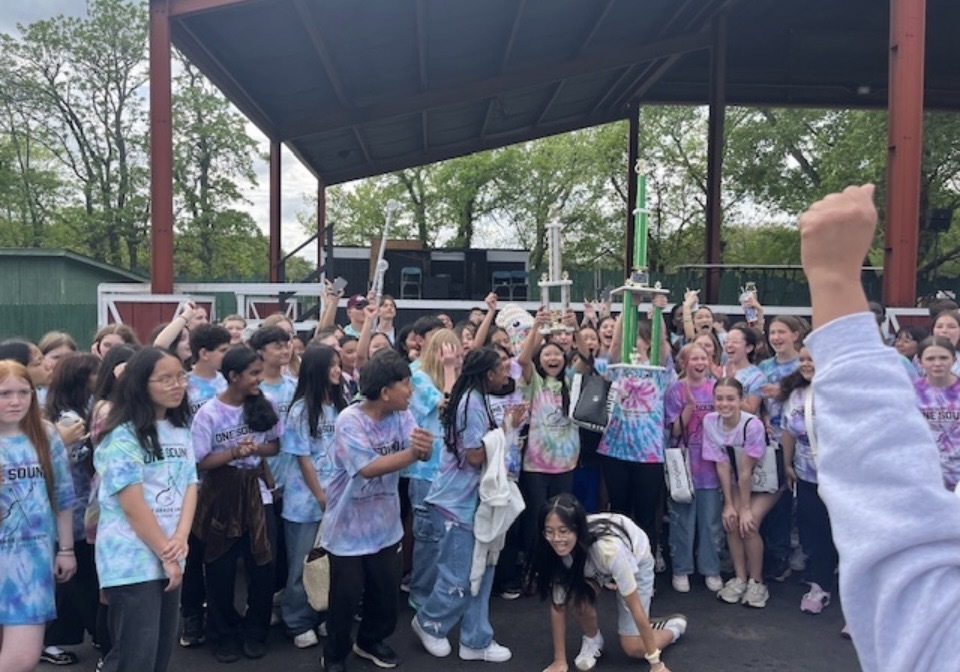 students holding up trophies and cheering