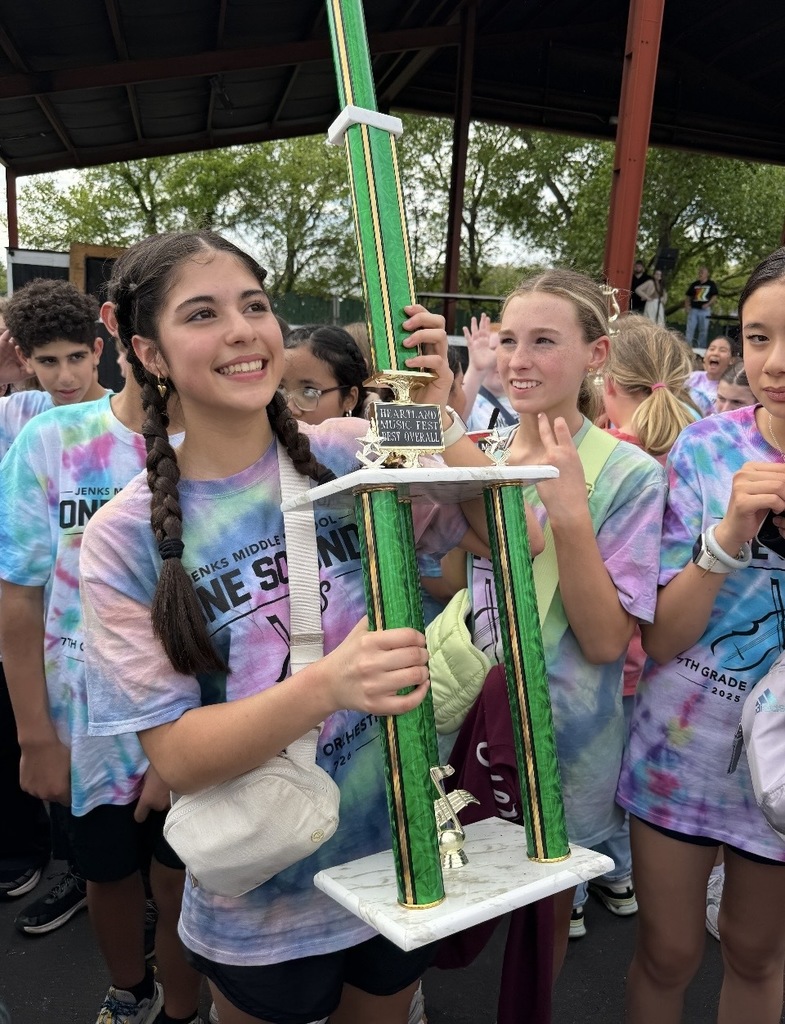 orchestra students smiling and holding trophy
