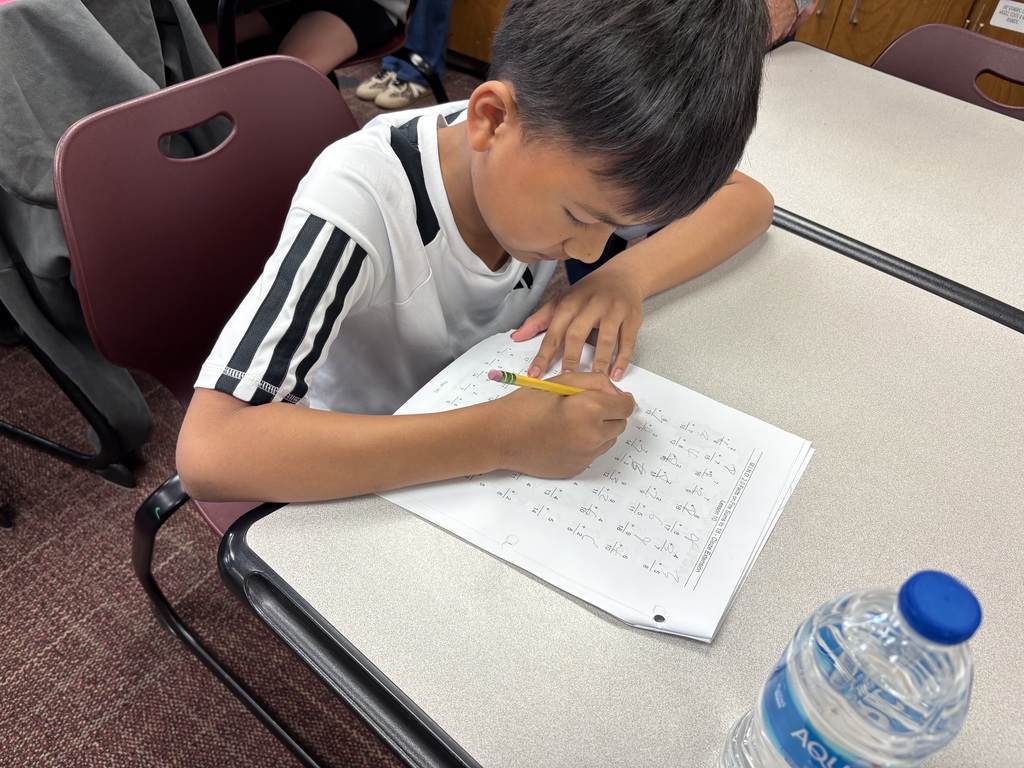 Fifth grade boy working on math problems at desk