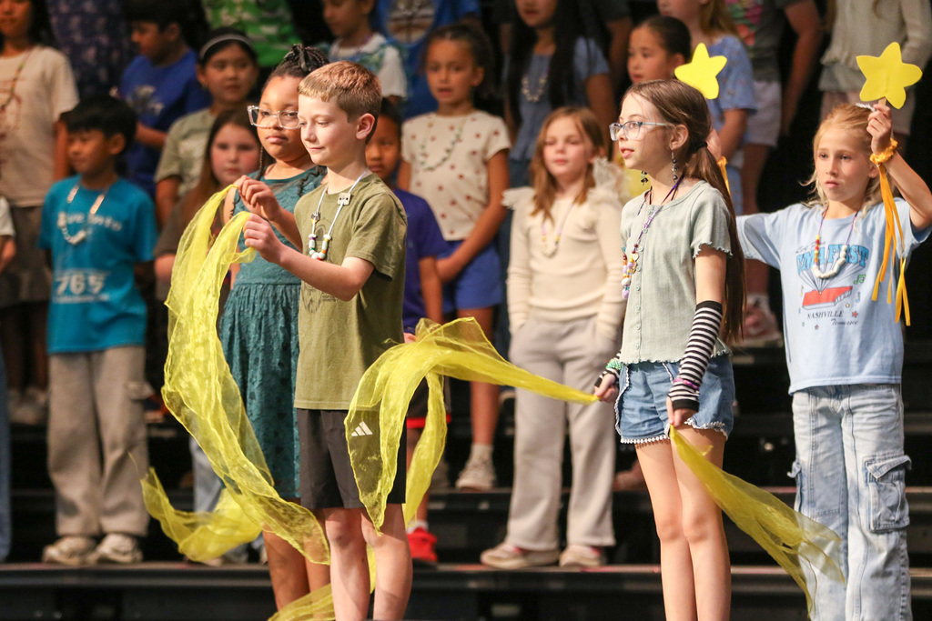 Students using  yellow fabric and stars for a dance routine