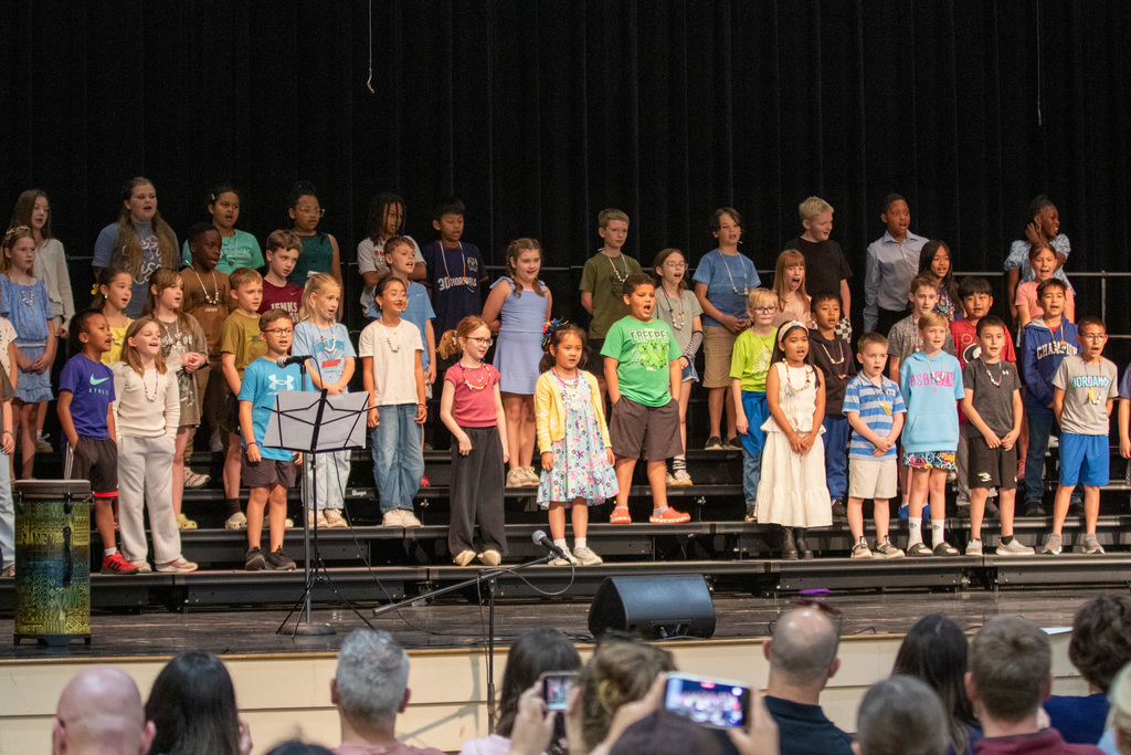 wide photo showing all the students singing while on risers