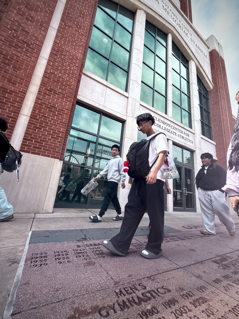 Jenks High School students walking in front of athletic building at University of Oklahoma