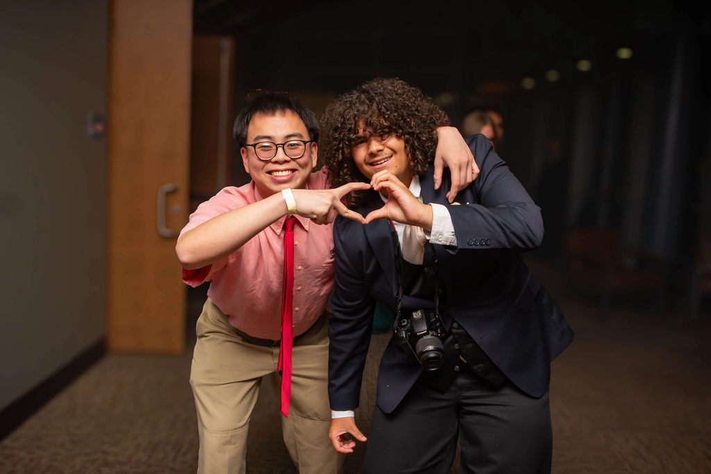 two boys at prom making a heart with their hands