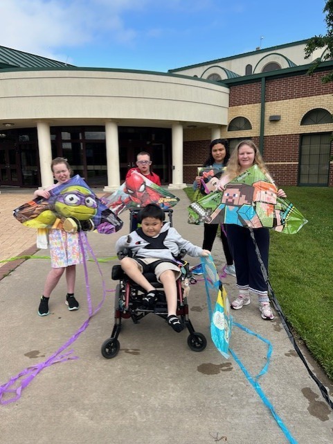 students holding kites