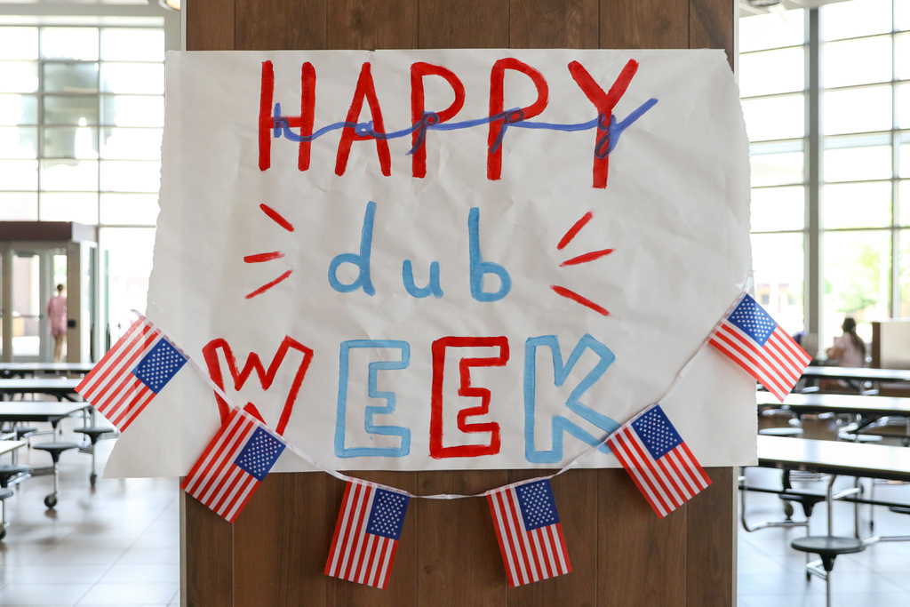 painted sign that says happy dub week in red and blue with american flags underneath