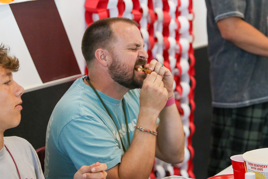 teacher biting into his spicy wing