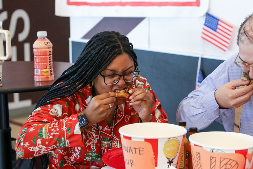 teacher biting into her spicy chicken wing