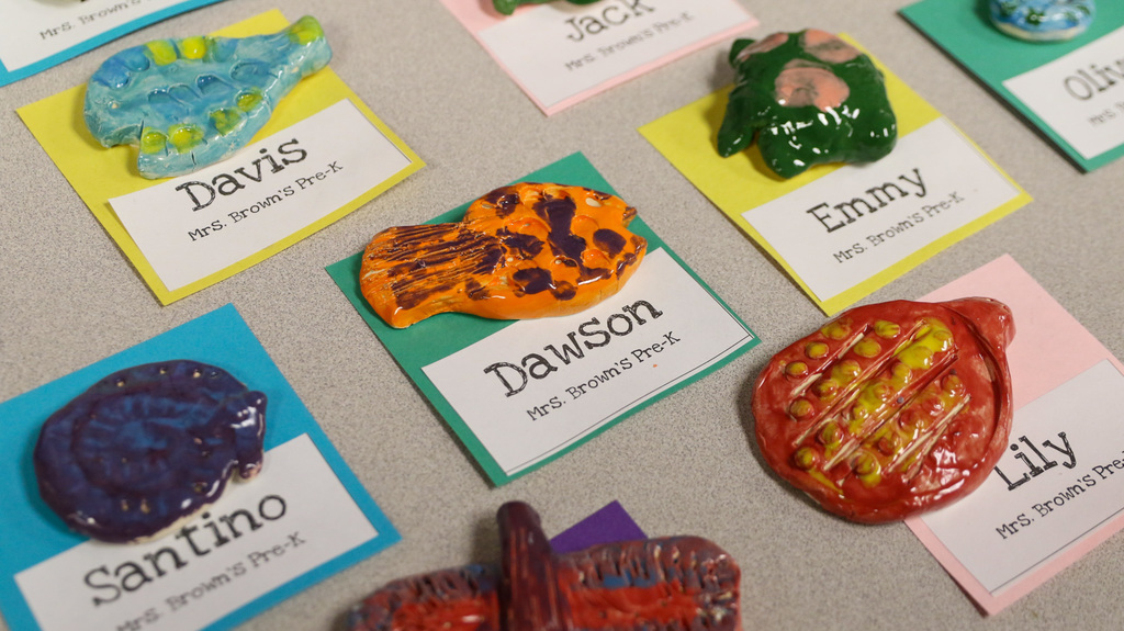 close up images or clay sculptures with the students names next to them on paper