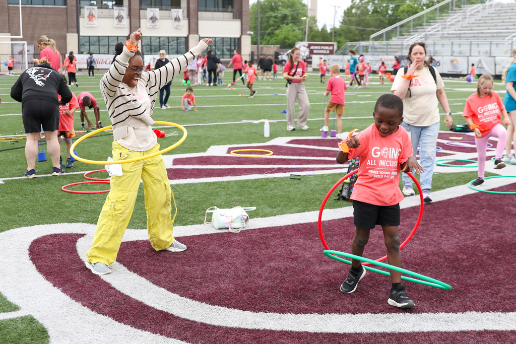 staff member and boy hula hooping. 