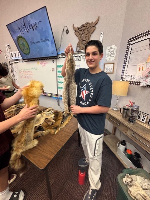 students holding animal pelts
