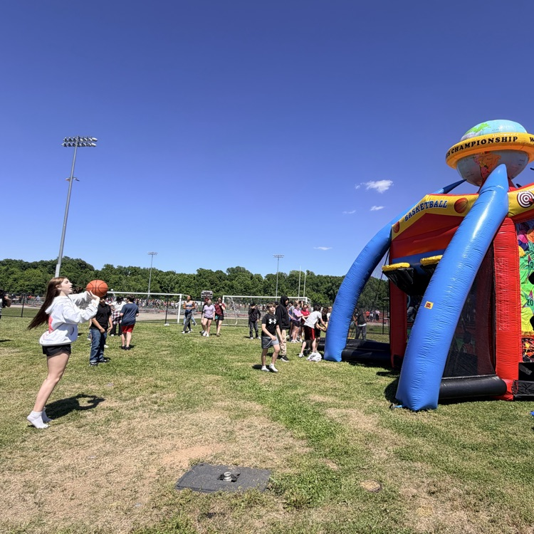 student shooting a basketball into an inflatable 