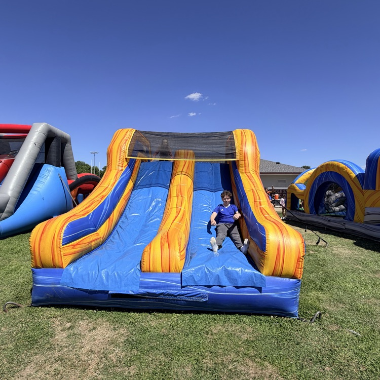 one student sliding down inflatable 