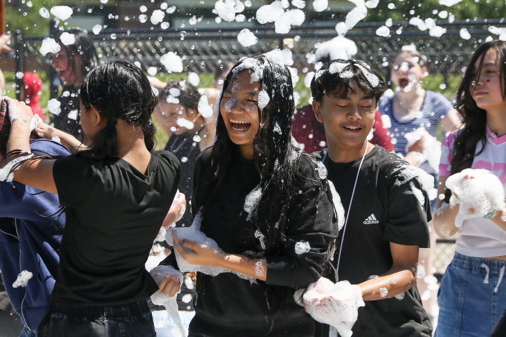 girl smiling with foam bubbles on her and in the air w