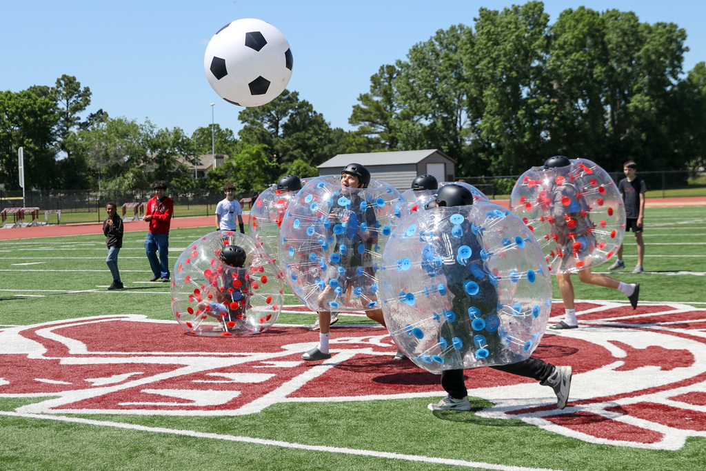 Boys in inflatable balls playing soccer. soccer ball is high in the air