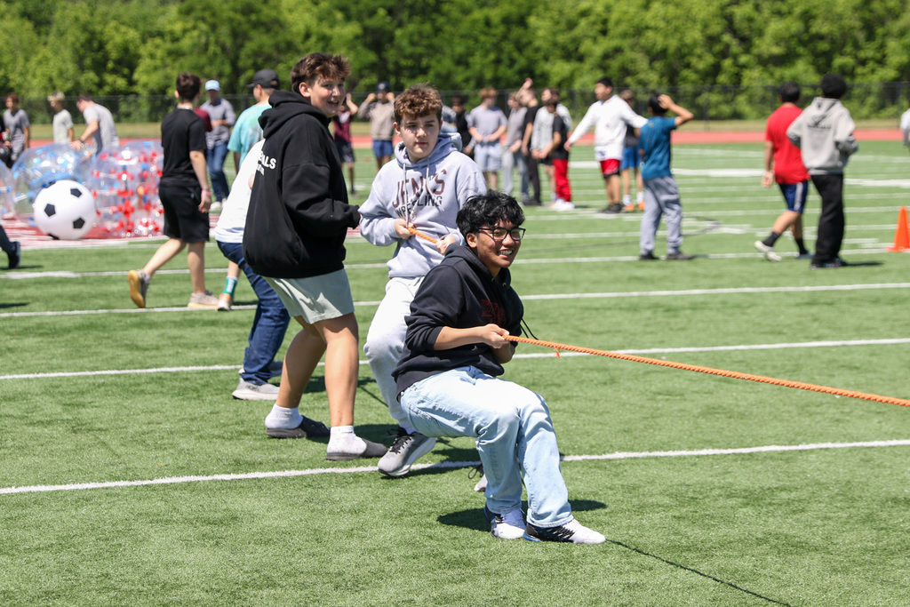 4 boys pulling on rope in a game of tug of war