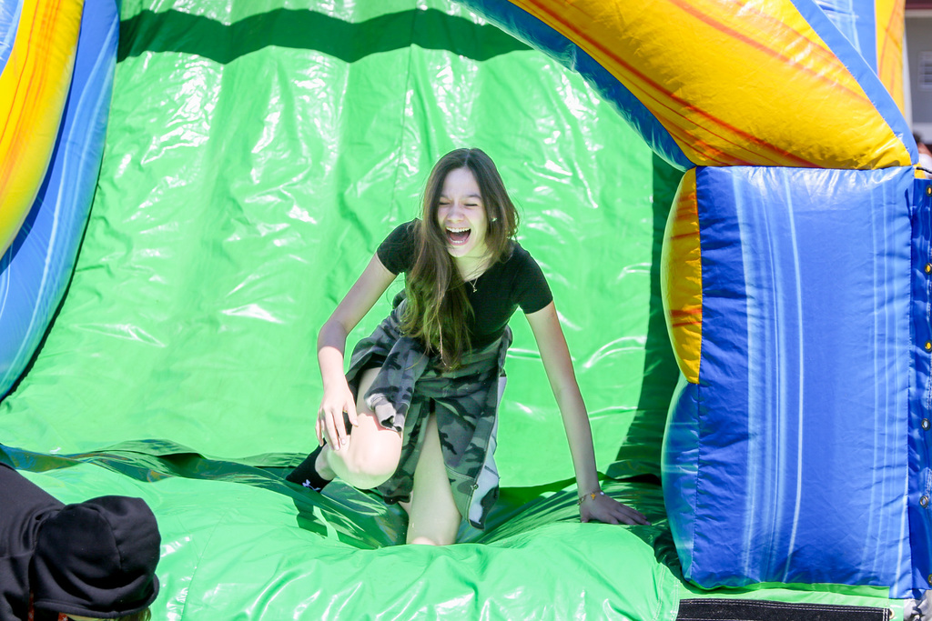 girl laughing sliding down an inflatable