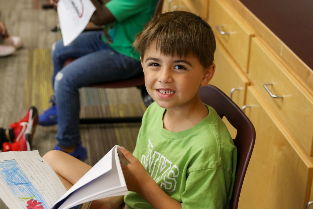 boy smiling with his research book