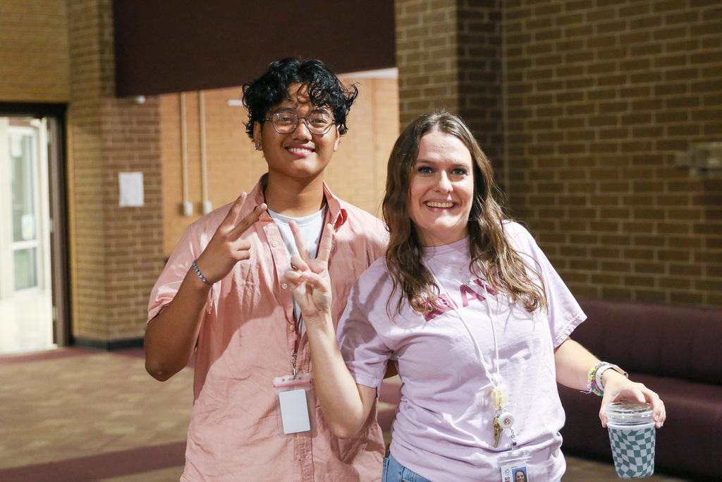 avid student and teacher posing with the peace sign with their finger