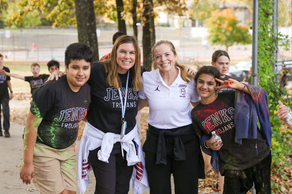 two students and two teachers outside at a color run pausing for a photo