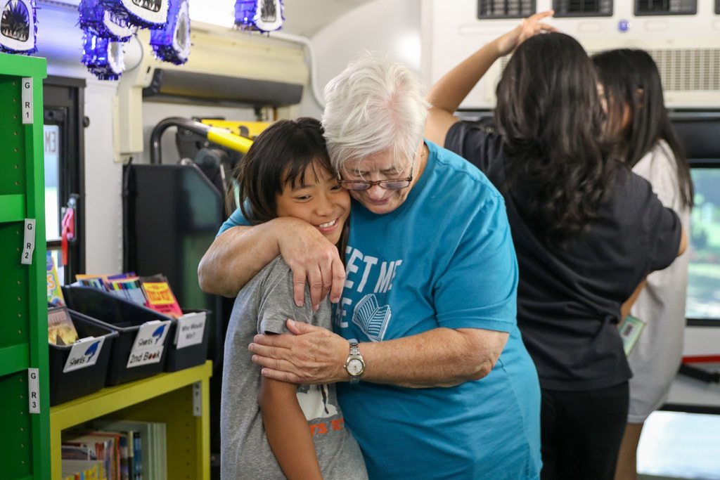 teacher and student hugging on the bookmobile