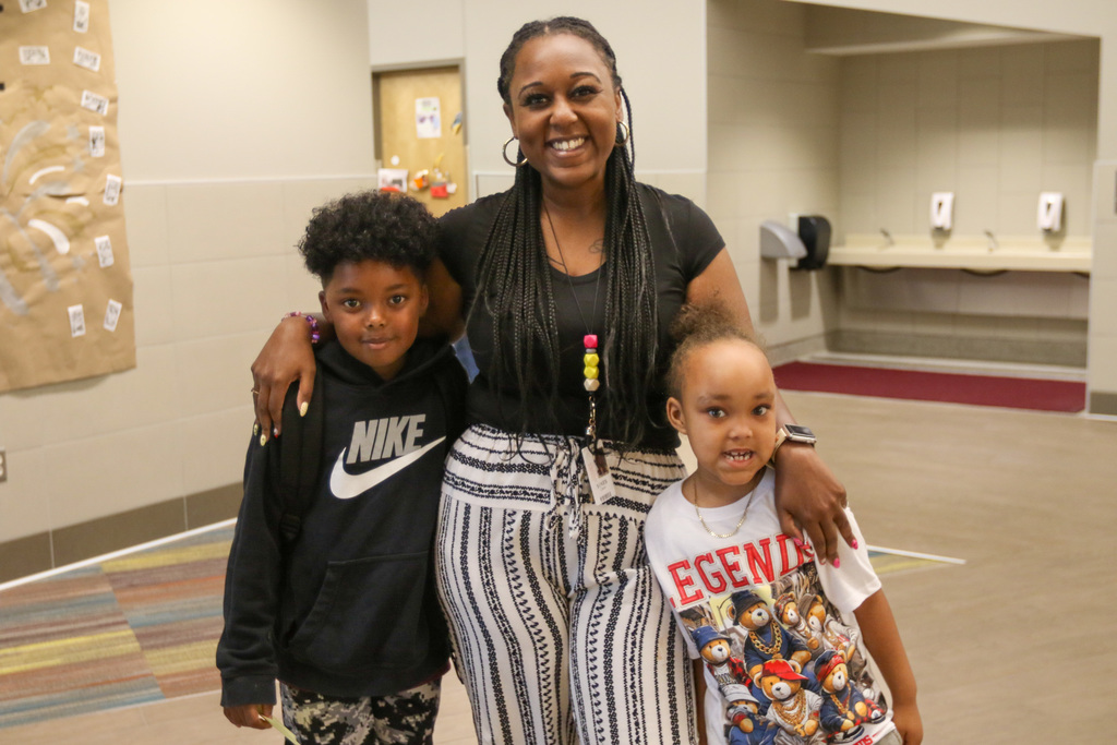 teacher and two boys in the hallway smiling for a photo
