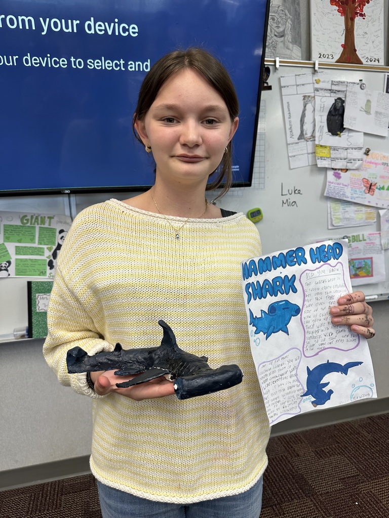 student holding poster & shark figure