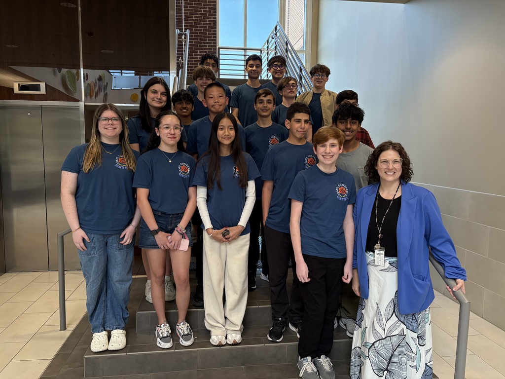 Group of 17 middle school students on staircase posing with STEM teacher after being recognized by JPS Board of Education