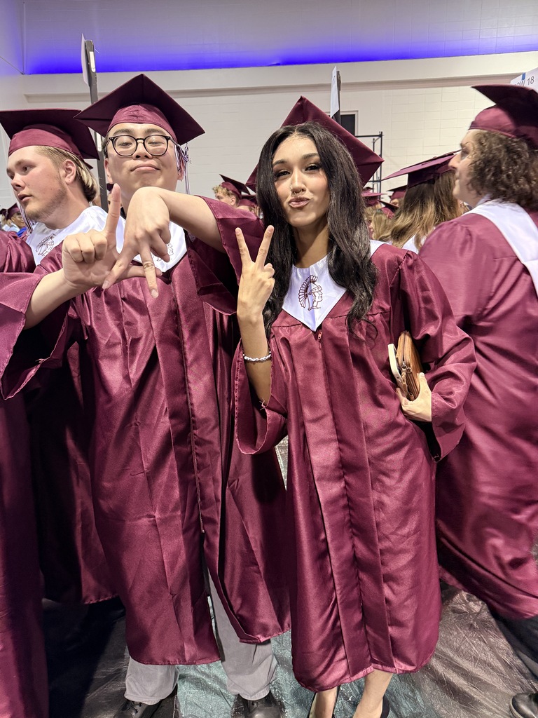 Two students in graduation gowns