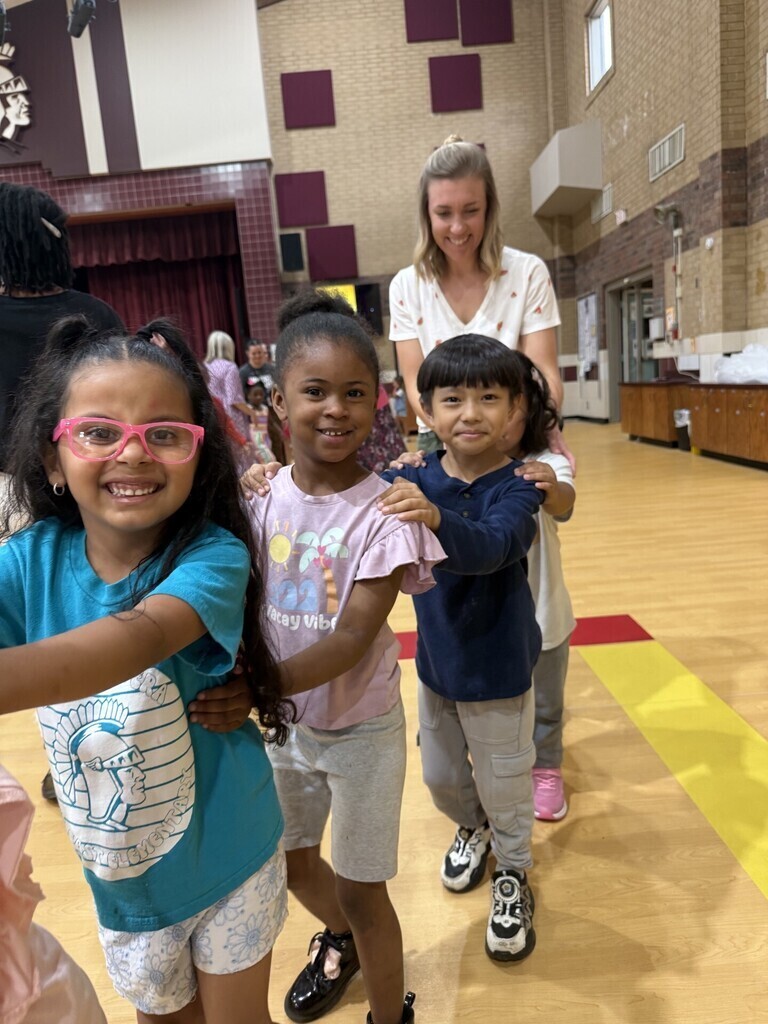 Teacher helps student form a conga line at the WIG celebration