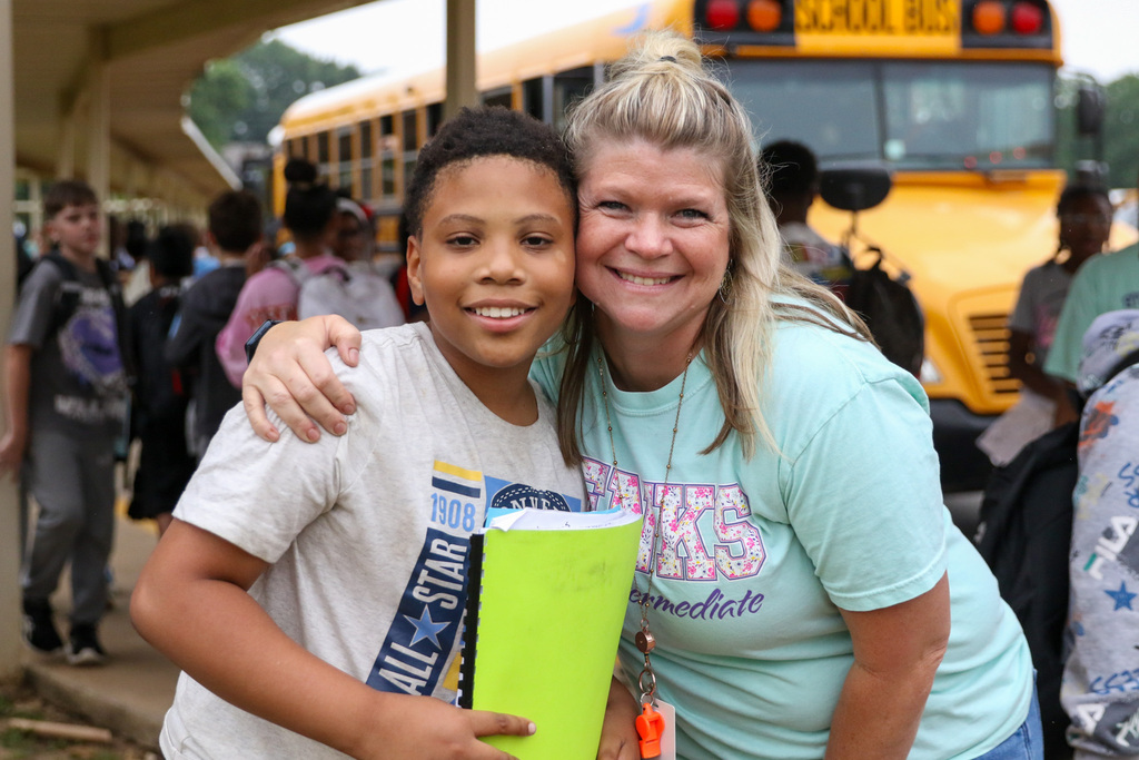 teacher and student pose for a photo