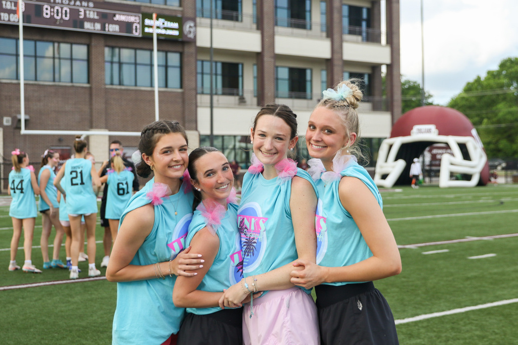 4 senior girls pose for a photo on the field before the game