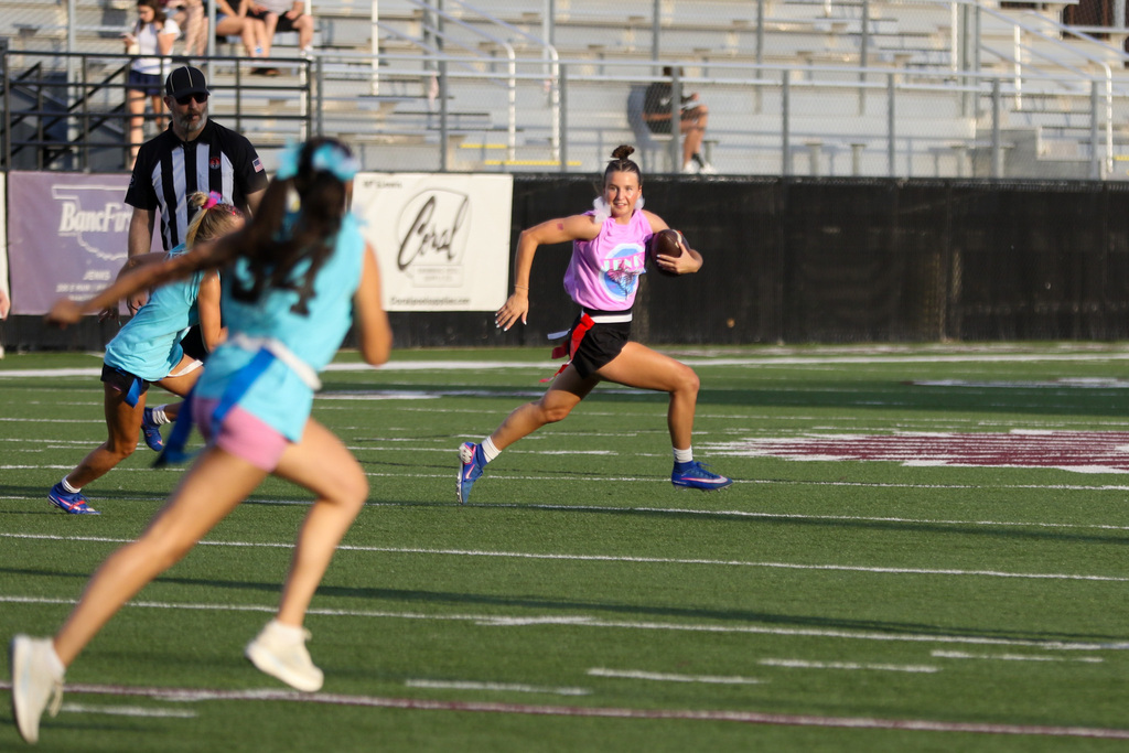 junior girl running the ball and two seniors running towards her