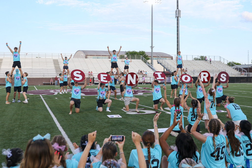 senior man cheer performing. holding up signs that spell out seniors