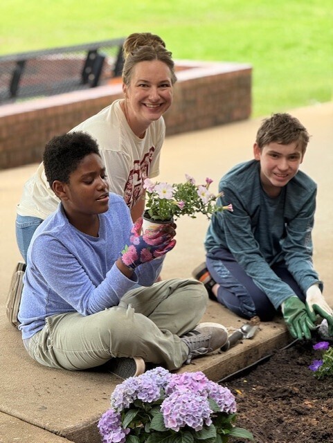 Peers with Purpose students and teacher planting flowers