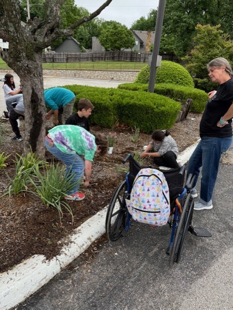 students planting flowers in front of school